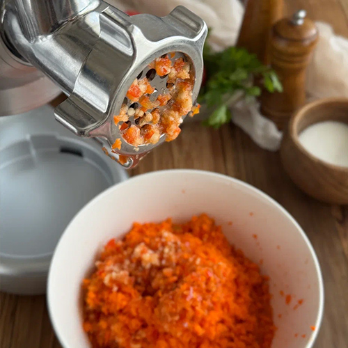 Пропустите перец, морковь и чеснок через мясорубку. Тщательно промойте и мелко нарежьте зелень.