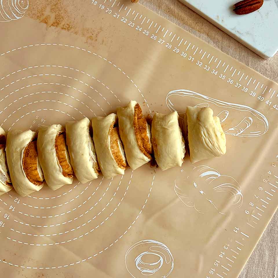 Скатайте тесто в рулон и нарежьте на кусочки толщиной около 4–5 см.