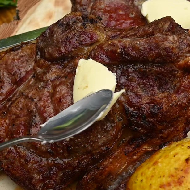 Снимите с гриля шампуры со стейками, шампиньонами и картофелем. К мясу добавьте немного сливочного масла — во вкусе стейка появятся сливочные нотки!