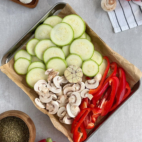 Полейте овощи и грибы растительным маслом, поперчите и посолите по вкусу, добавьте смесь прованских трав. Отправьте противень в разогретую до 170°С духовку примерно на 30 минут.