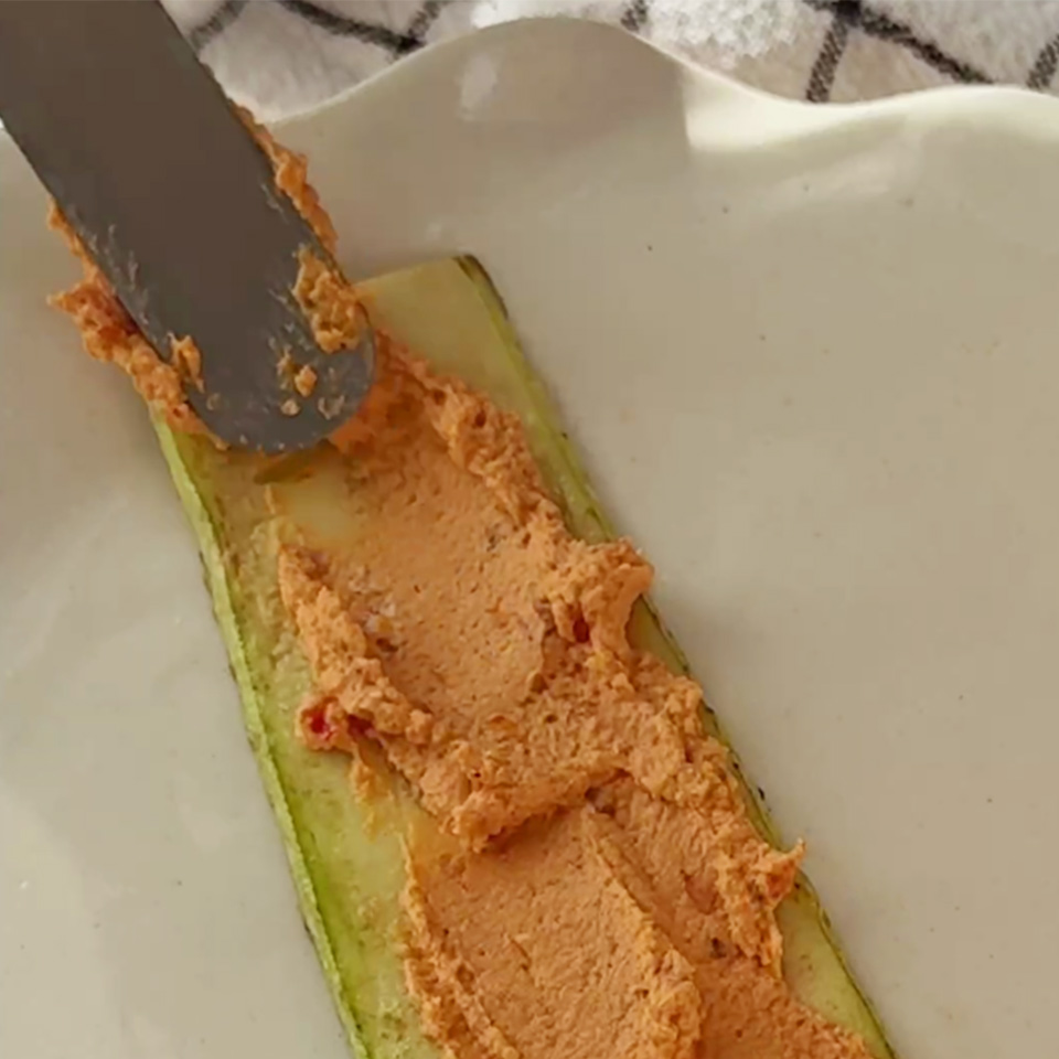Смажьте каждую пластинку кабачка начинкой.