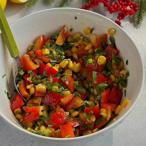 Нарезанные лук и перец соедините с кукурузой, добавьте заправку.