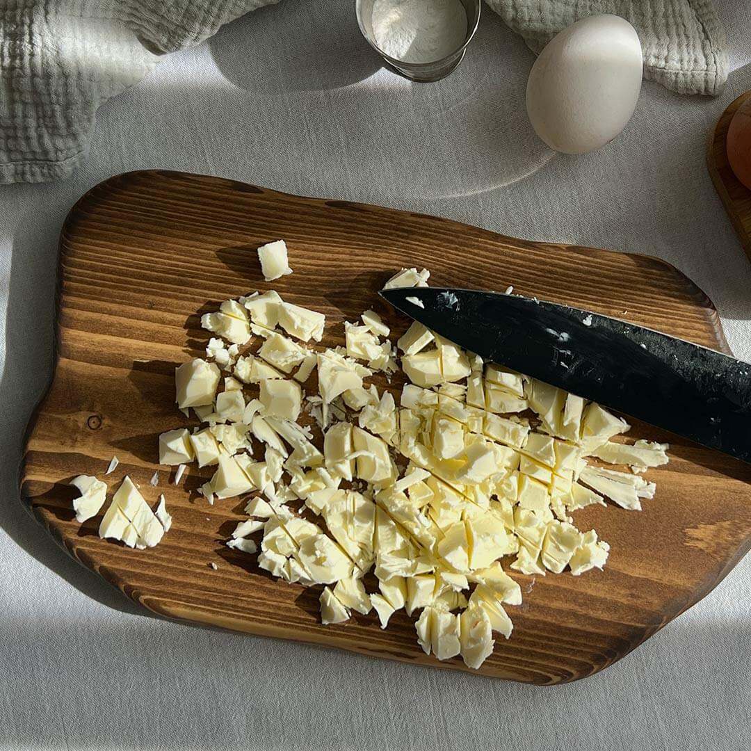 Нарежьте сливочное масло на произвольные небольшие кусочки