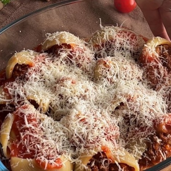 Сверху полейте оставшимся мясным соусом и посыпьте пасту тёртой моцареллой. Запекайте пасту в разогретой до 180°C духовке 15–20 минут до золотистой корочки.
