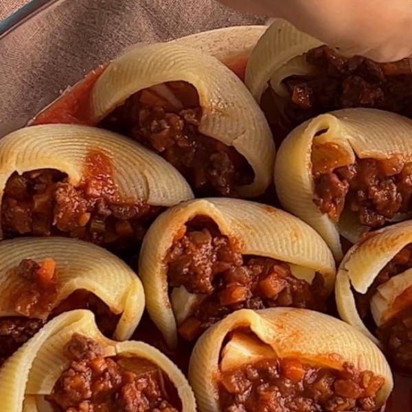 Аккуратно разложите фаршированные лумакони на форму для запекания.